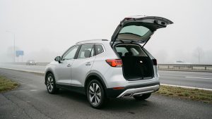 SUV familial moderne stationné en extérieur, coffre ouvert laissant voir l’espace de chargement, ambiance sobre et routière sous un éclairage naturel.