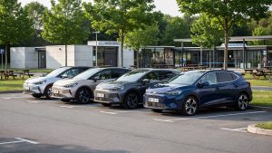 SUV hybrides compacts et familiaux stationnés en rangée sur une aire d’autoroute française, éclairés par une lumière naturelle.