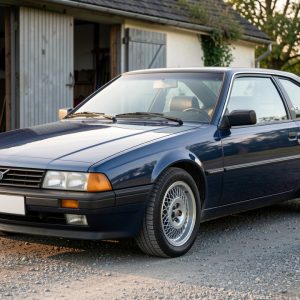 Une voiture familiale européenne des années 1980 en bon état, présentée de trois quarts sur une route de campagne.