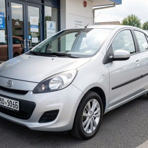 Voiture compacte d’occasion argentée présentée dans une concession automobile française lumineuse.